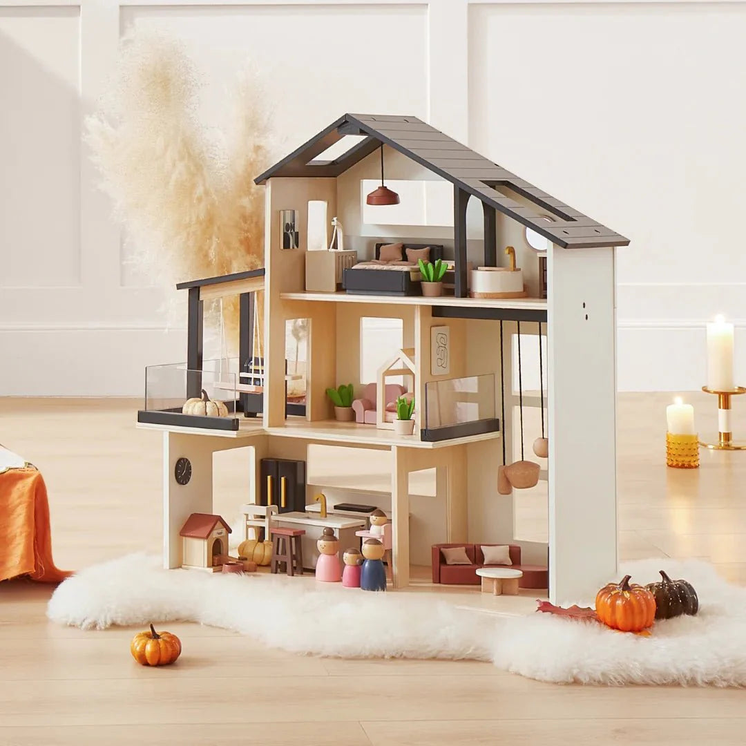 Wooden dollhouse with furniture and decorations on a wooden floor.