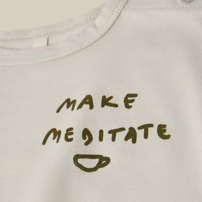 Text 'MAKE ME MEDITATE' printed on a light-colored fabric with a cup icon.