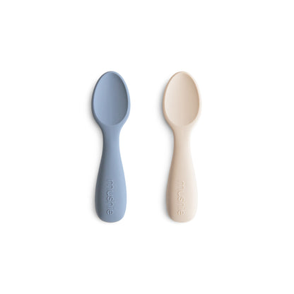 Two baby spoons, one blue and one beige, on a white background