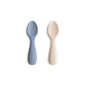 Two baby spoons, one blue and one beige, on a white background