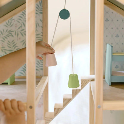 Children's room with a wooden playhouse and green hanging lamp.