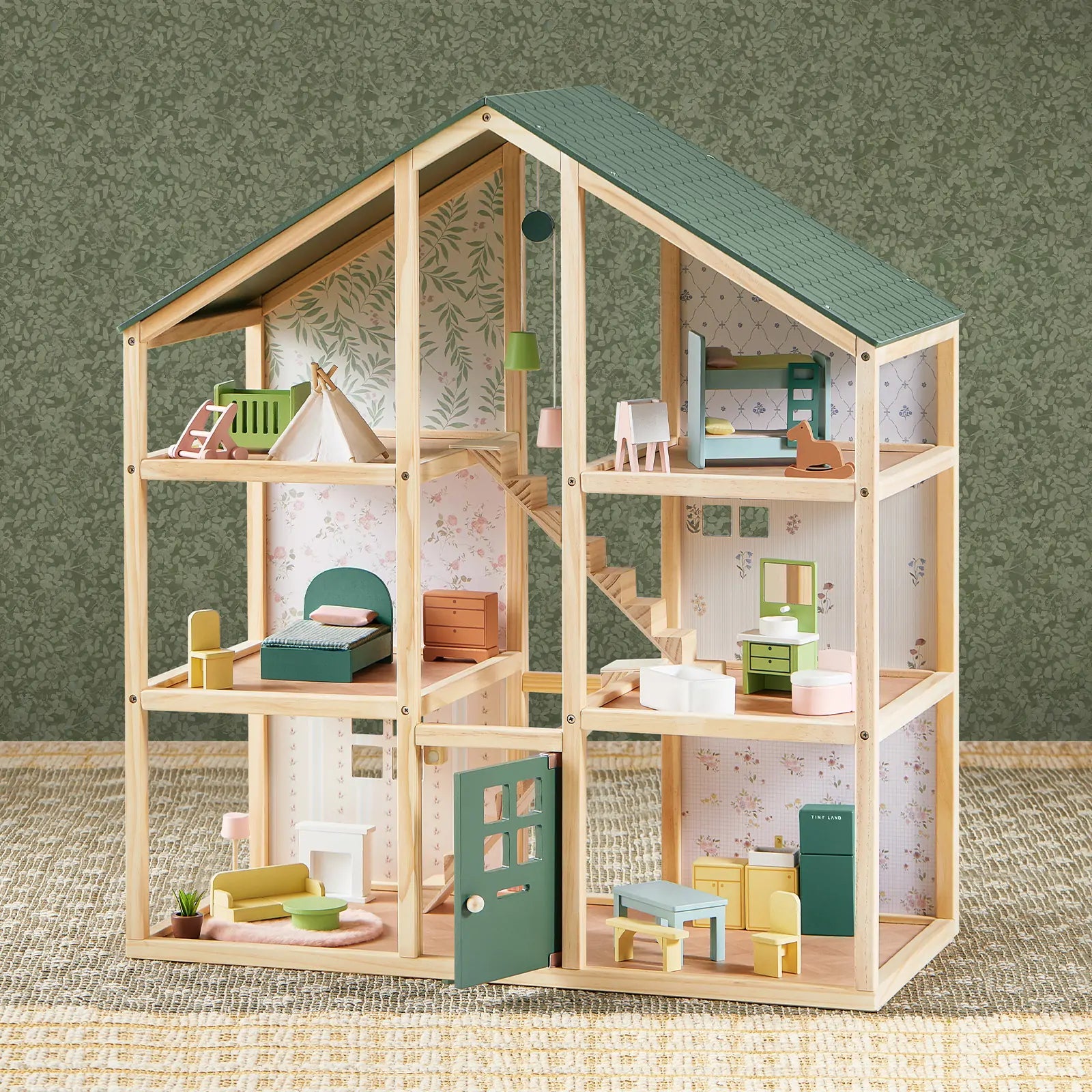 Wooden dollhouse with detailed interior and furniture on a textured surface.