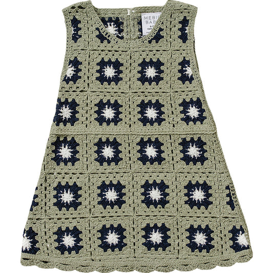 Crocheted dress with a pattern of black and white star shapes on a white background