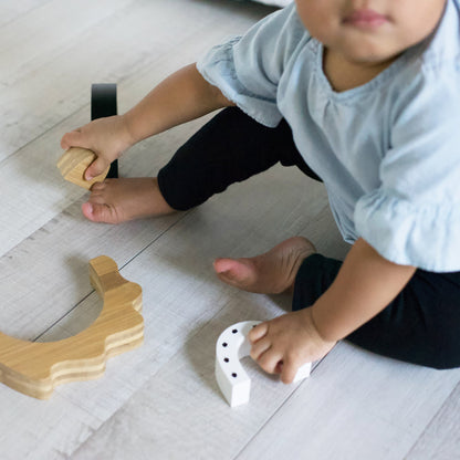 Child playing with wooden toys on a light wooden floor
