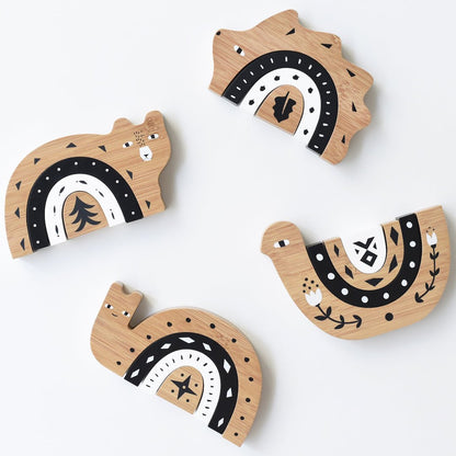 Wooden toys shaped like animals with black and white patterns on a white background