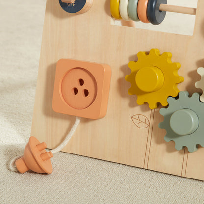 Wooden toy with gears and a button on a beige background