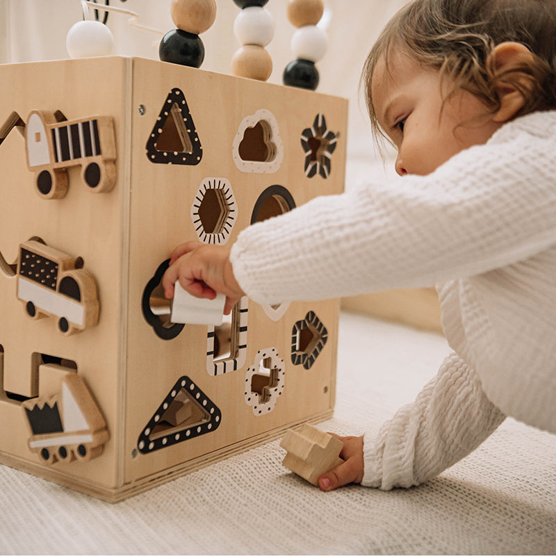 Child playing with a wooden shape sorting toy