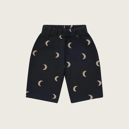 Navy blue pants with moon pattern on a beige background