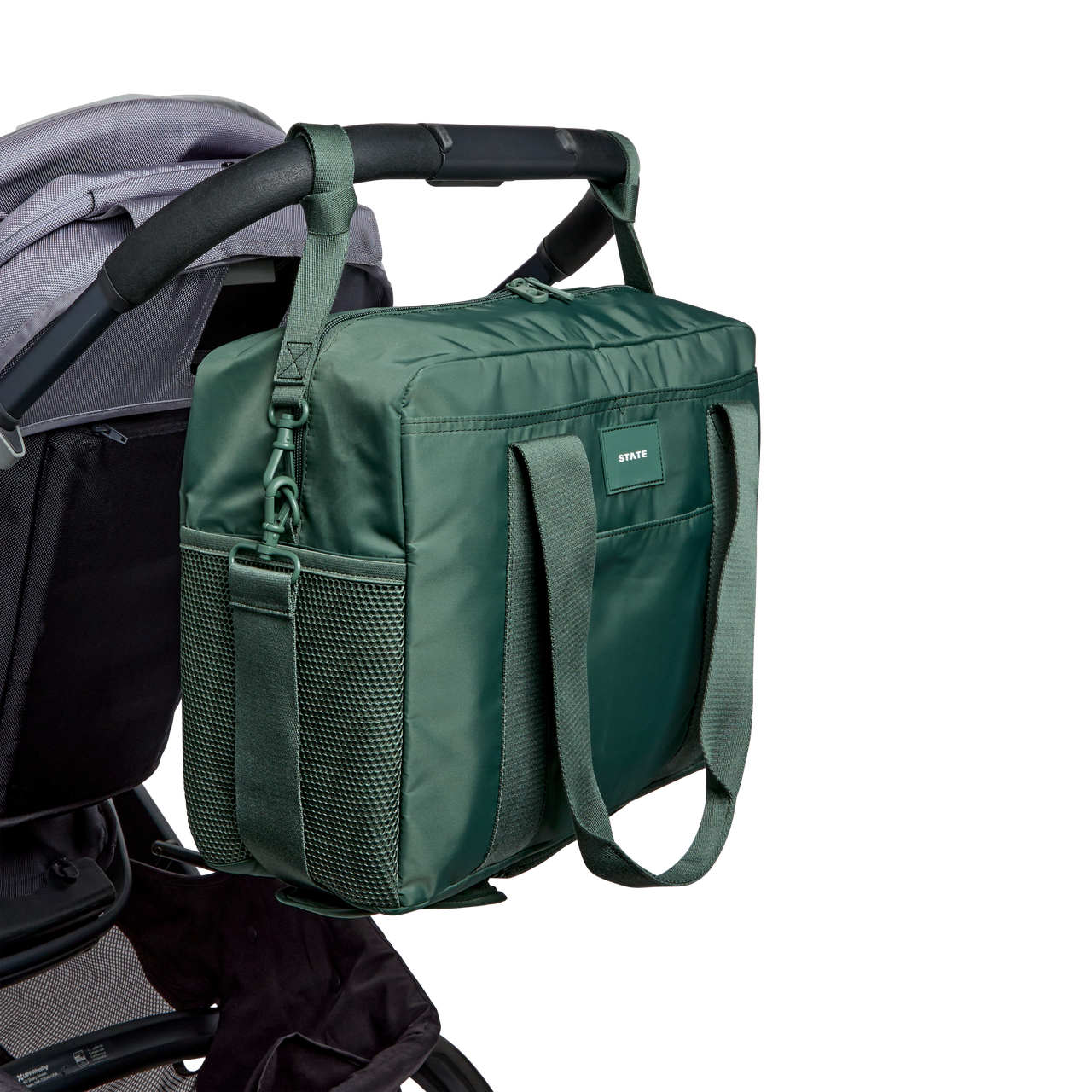 Green diaper bag attached to a stroller on a white background