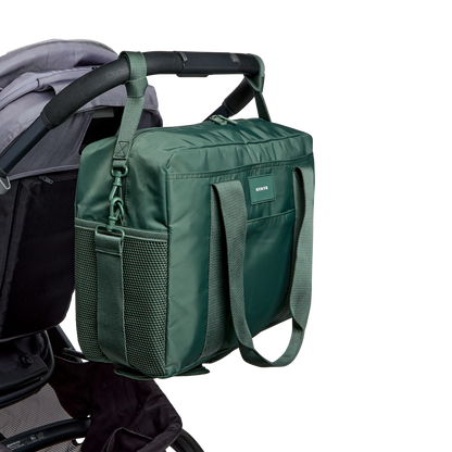Green diaper bag attached to a stroller on a white background