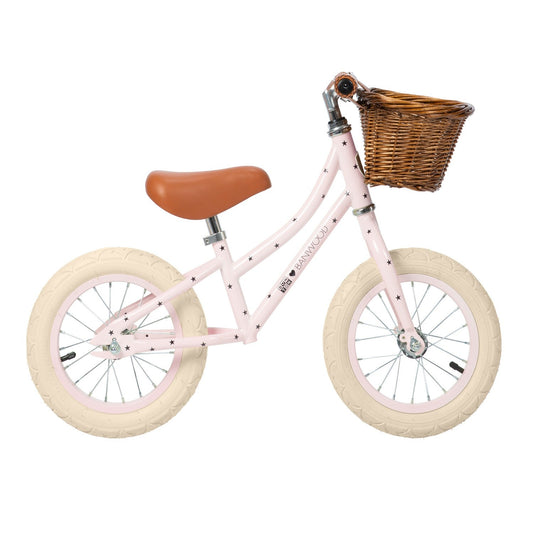 Pink children's bicycle with a brown basket on a white background