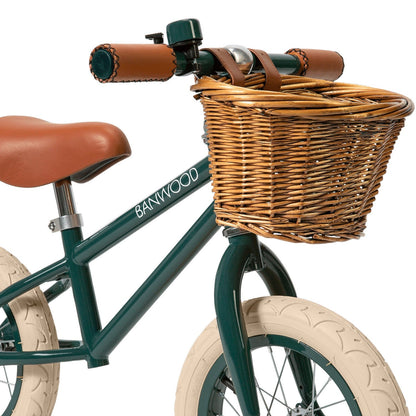 Children's bicycle with wicker basket and brown seat on a white background
