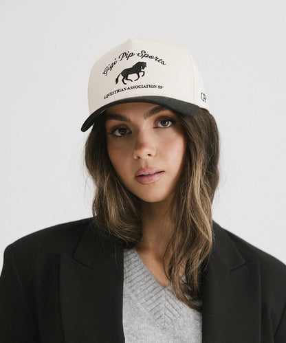 Woman wearing a cap with text and logo on a plain background