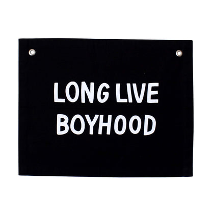 Black sign with white text 'LONG LIVE BOYHOOD' on a white background