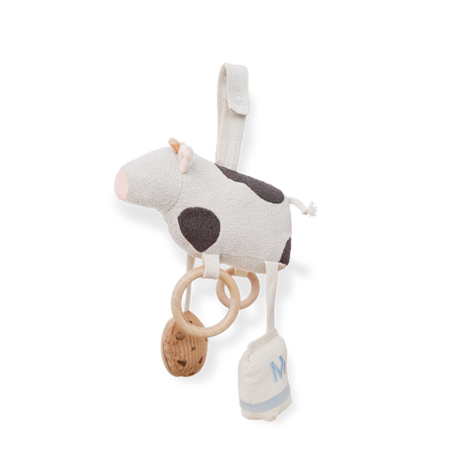 Plush cow toy with rattle and pacifier clip on a white background