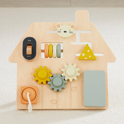 Wooden toy with various shapes and a house design on a light background