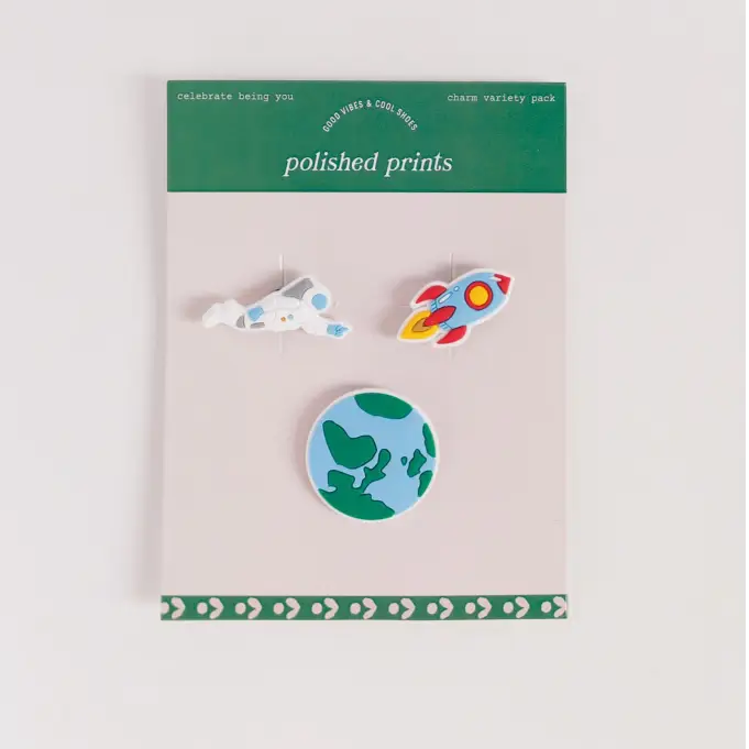 Set of three enamel pins on a 'polished prints' branded card against a light gray background