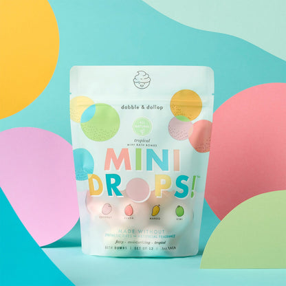 Package of 'Mini Drops' bath bombs with colorful design on a blue background