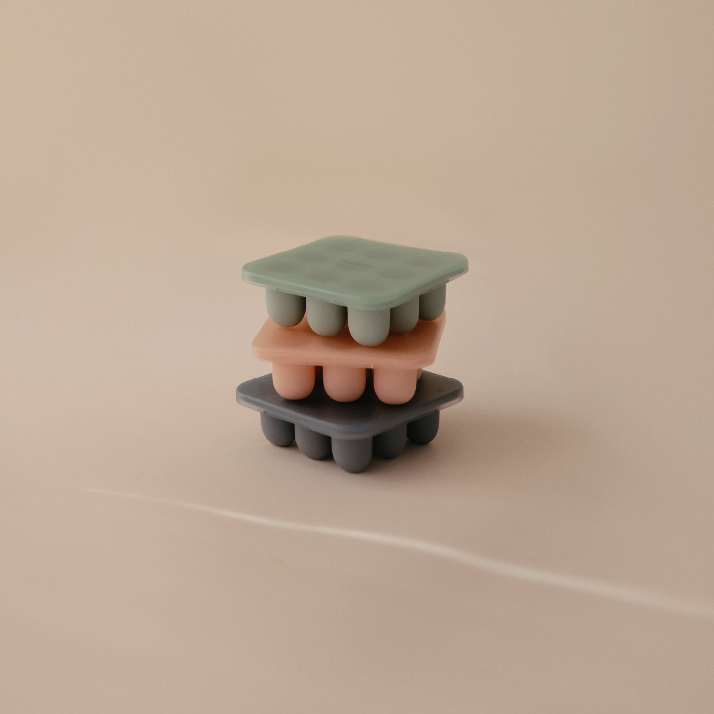 Silicone ice cube tray with multiple molds on a beige background