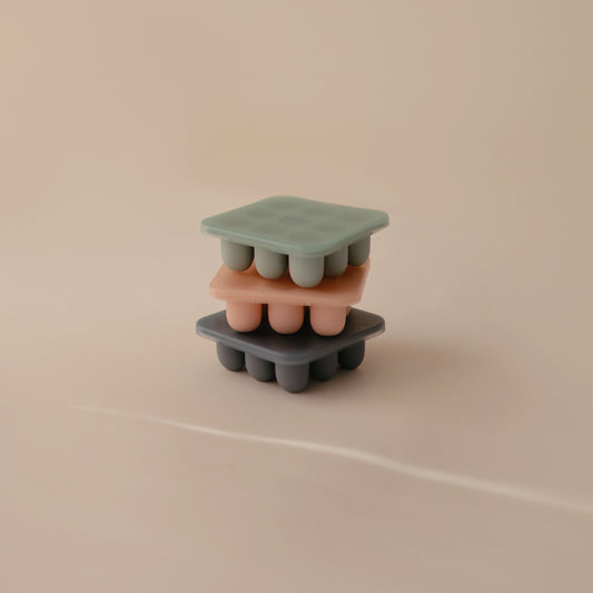 Silicone ice cube tray with multiple molds on a beige background