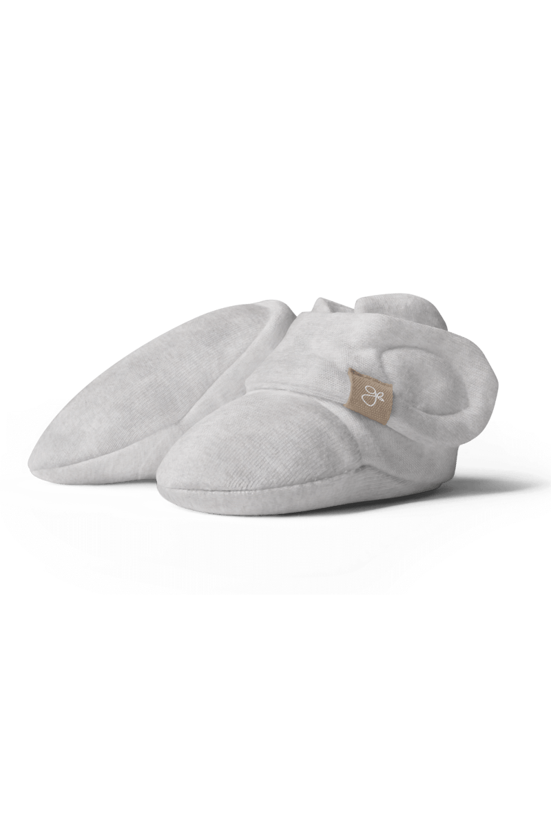 Light gray baby booties with a brand logo on a transparent background