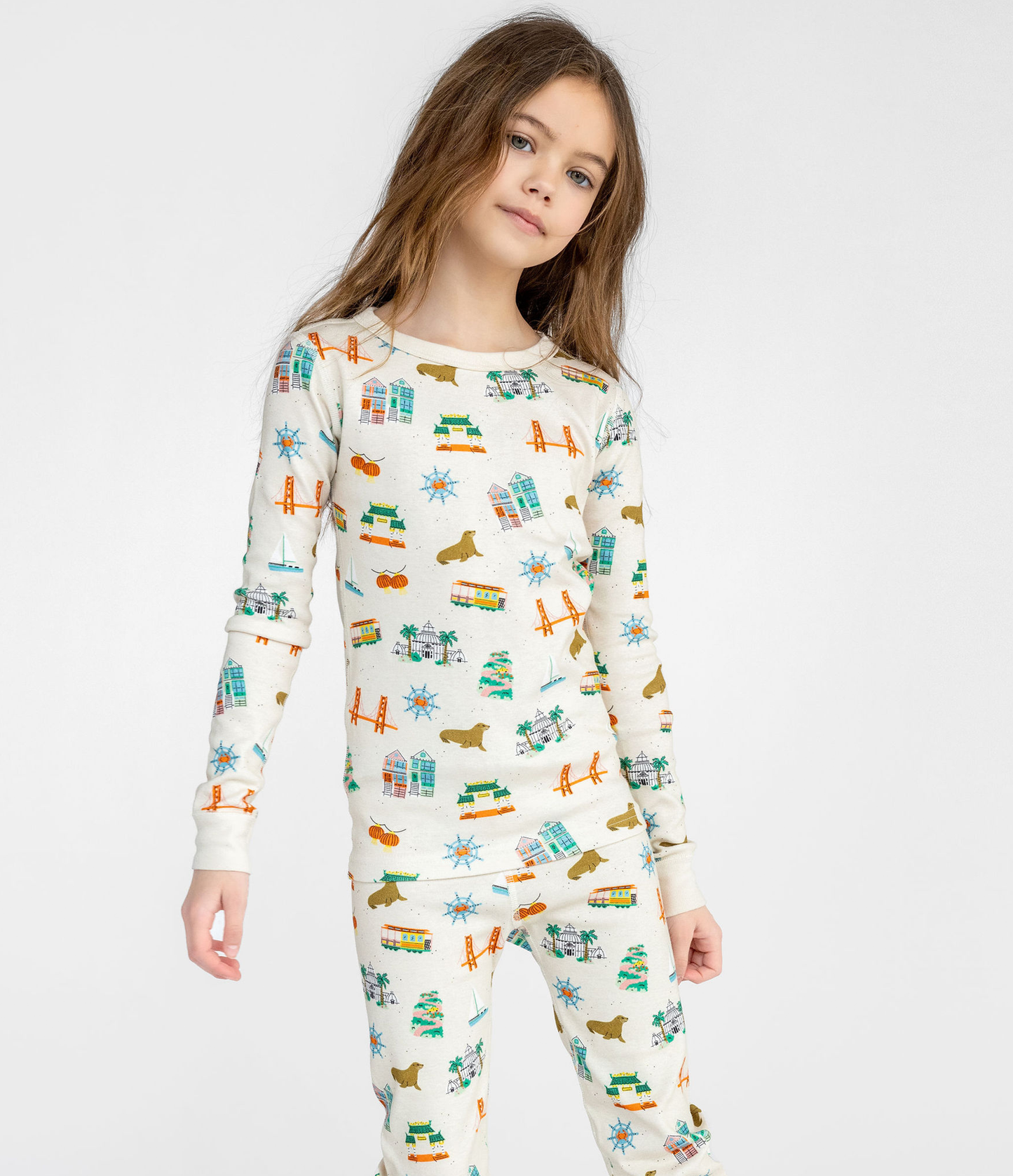 Child wearing a San Francisco themed patterned pajama set on a white background