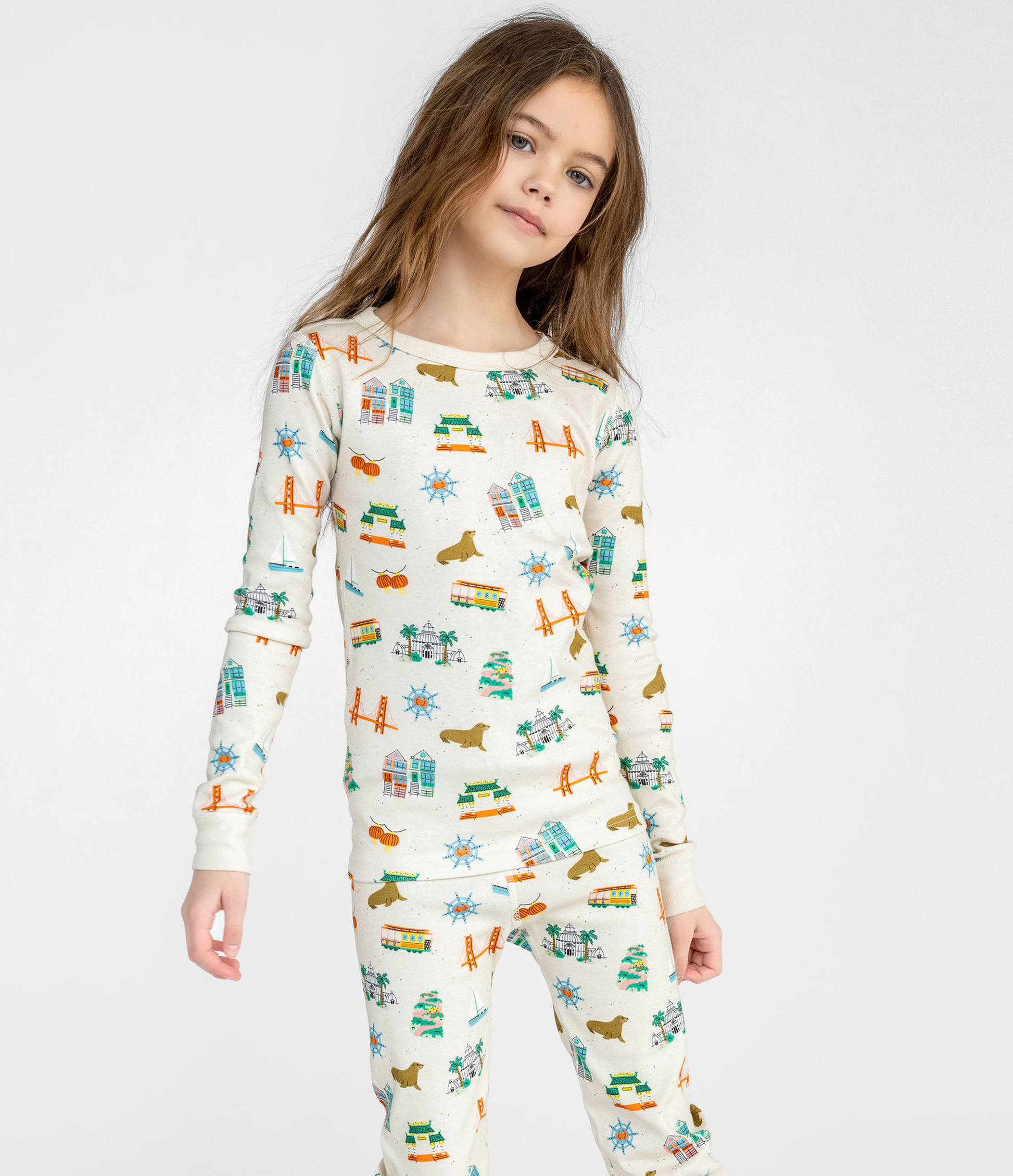 Child wearing a San Francisco themed patterned pajama set on a white background