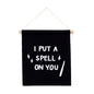 Black banner with white text 'I PUT A SPELL ON YOU' hanging on a white background