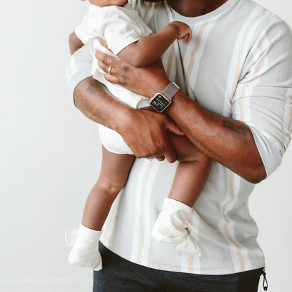 Man holding a child against a plain background
