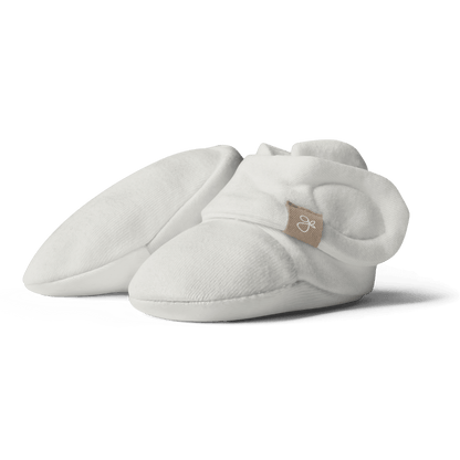 White baby booties with a brand logo on a transparent background