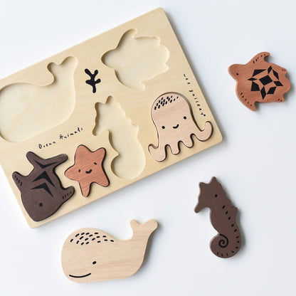 Wooden puzzle with ocean-themed shapes on a white background