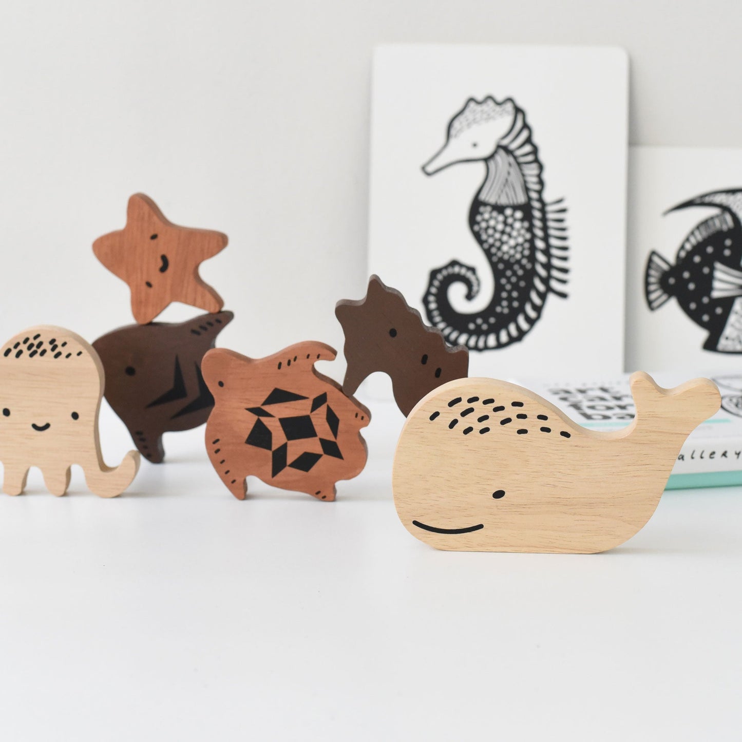 Wooden toys shaped like marine animals on a white surface with a light gray background.