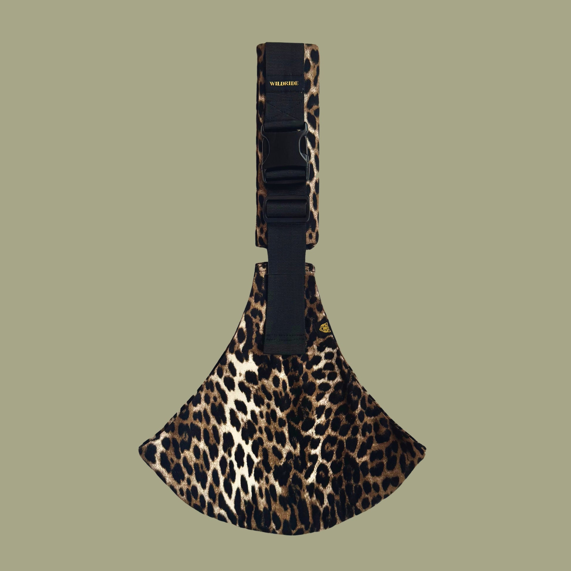 Leopard print toddler carrier with black strap on a green background